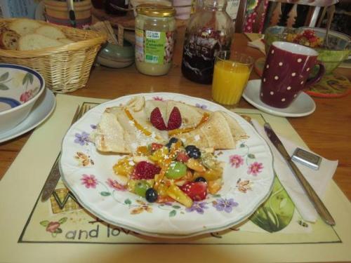a plate of food with fruit and crackers on a table at Le Gîte Ambrelane in Thetford Mines