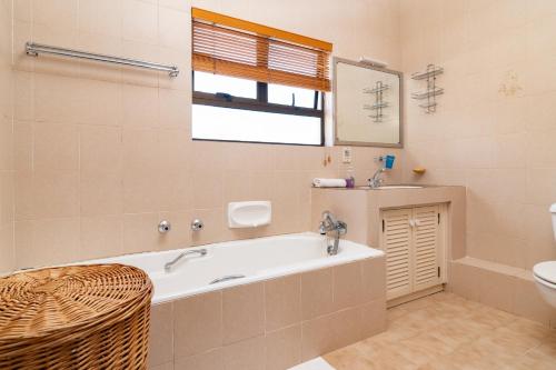 a bathroom with a tub and a sink and a toilet at Chaka Terraces 10 in Ballito