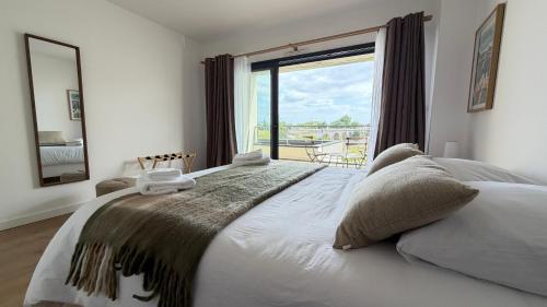 a bedroom with a large bed with a large window at Les Oiseaux de Loire in Les Ponts-de-Cé