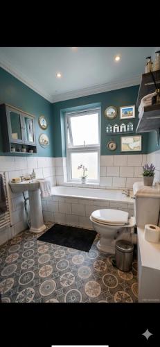 a bathroom with a tub and a toilet and a sink at Double Room - Folkestone Harbour in Kent