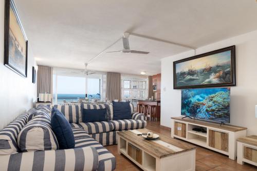 a living room with a couch and a tv at Chakas Cove 34 in Ballito