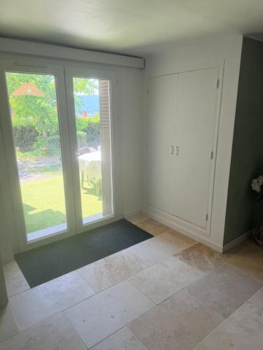 an empty living room with large windows and a door at Studio avec terrasse et parking privé in Château-Arnoux-Saint-Auban