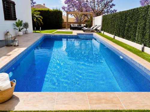 a swimming pool with blue water in a backyard at Lux Villa with Year-Round Heated Pool & Game Room in Montequinto