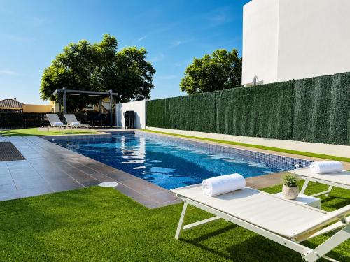 a swimming pool with two lounge chairs in a yard at Lux Villa with Year-Round Heated Pool & Game Room in Montequinto