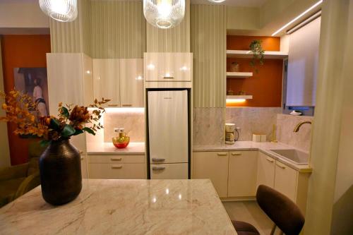 a kitchen with a table and a vase with flowers at Chrysiida Luxury Apt, Stroll to Nafplio Center in Nafplio