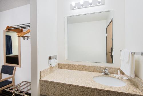 a bathroom with a sink and a large mirror at Super 8 by Wyndham Humboldt in Humboldt