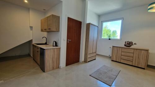 a kitchen with a sink and a wooden door at Bos-Znam Pokoje in Gdynia