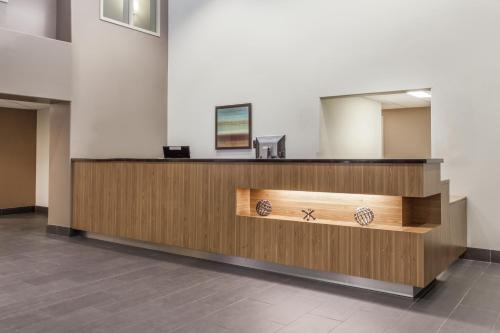 a reception desk in a room with a mirror at Super 8 by Wyndham Peterborough in Peterborough