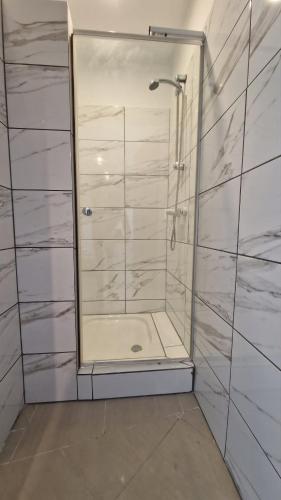 a shower with a glass door in a bathroom at Bos-Znam Pokoje in Gdynia