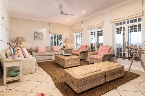 a living room with couches and chairs and windows at Colwyn Drive 53 in Sheffield Beach