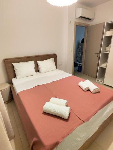 a bedroom with a large bed with two towels on it at Luxury Suite Gala in Nikiti