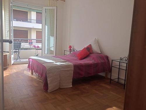 ニースにあるLe Palais Martineのベッドルーム1室(赤い枕のベッド1台付)