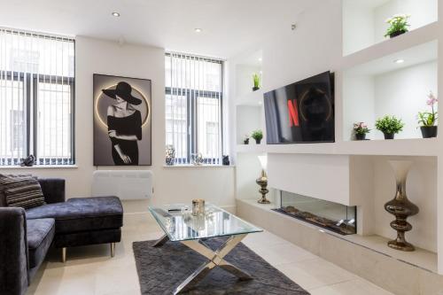 a living room with a couch and a glass coffee table at Bradford Chic City-Centre Apartment in Bradford
