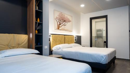 a hotel room with two beds and a mirror at Suiteincenter Rooms in Palermo