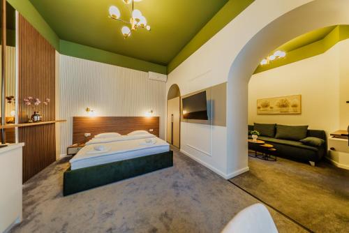 a bedroom with a large bed and a couch at BOUL ROSU RESIDENCE free private parking in Arad