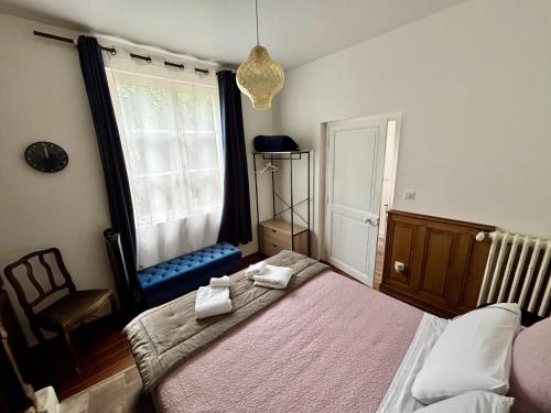 a bedroom with a bed and a chair and a window at L'Atelier des Rêves Amboise in Amboise