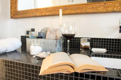 an open book on a counter with a glass of wine at Casa Montalgallo in Lucignano