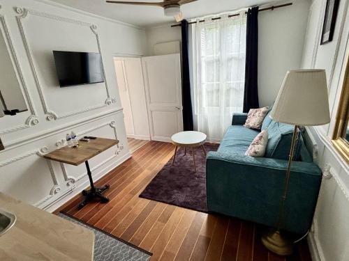 a living room with a blue couch and a table at L'Atelier des Rêves Amboise in Amboise