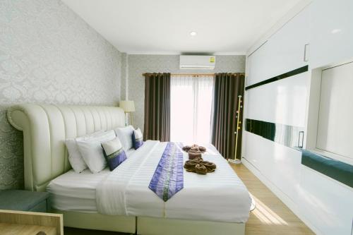 a bedroom with a large bed with white sheets at Amphawan in Ban Nong Khrai Luang