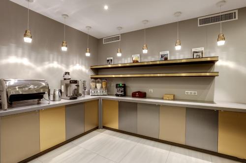 a kitchen with yellow and gray counters and lights at Hotel d'Amiens in Paris