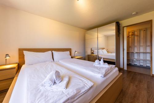 a bedroom with a large white bed with towels on it at Luna in Thun