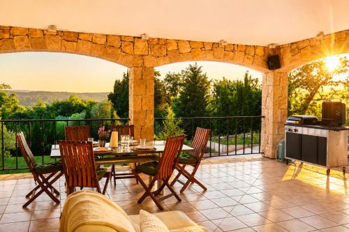 an outdoor patio with a table and chairs and a kitchen at Villa Lavendel in Montauroux