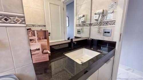 a bathroom with a sink and a phone at SHB - Central Miramar Shopping Mall from the beach in Santos