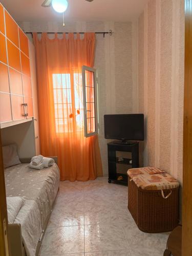 a bedroom with a bed and a flat screen tv at Casa vacanza da Sandro in Priolo Gargallo