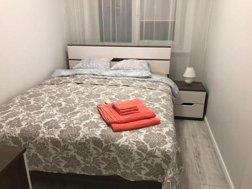 a bedroom with a bed with a red towel on it at Central Boulevard Apartment in Šiauliai