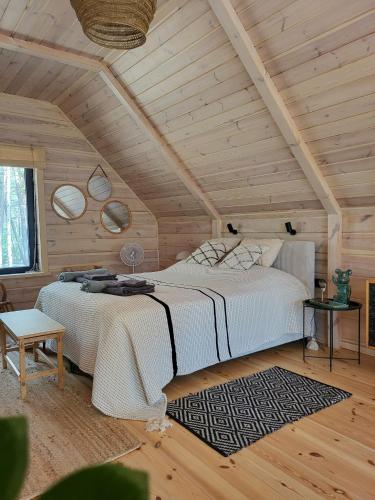 a bedroom with a large bed and wooden ceilings at Nobelowka Forest SPA in Huta Podgórna
