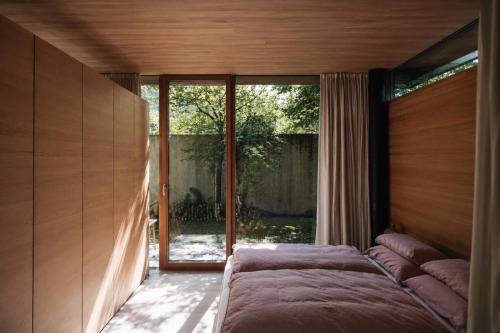 a bedroom with a bed in front of a window at Haus am Felsen, Ferien in Vorarlberger Architektur in Bregenz
