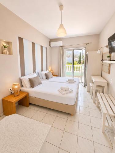 ein Schlafzimmer mit einem großen Bett und einem Balkon in der Unterkunft Ilios Stalis in Stalida