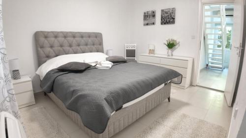 a bedroom with a large bed in a white room at Stone House Perast in Kotor