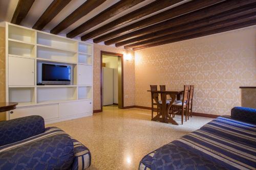 a room with a bed and a table with a tv at Home Venice Apartments - Piazzale Roma in Venice