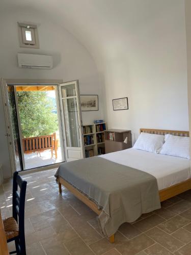 a bedroom with a bed and a sliding glass door at Studio Gaia in Kythira