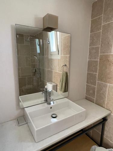 a bathroom with a white sink and a mirror at Studio Gaia in Kythira