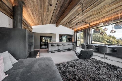 a bedroom with a couch and chairs in a room at GOING TRIPLE A apartments EAST in Going am Wilden Kaiser