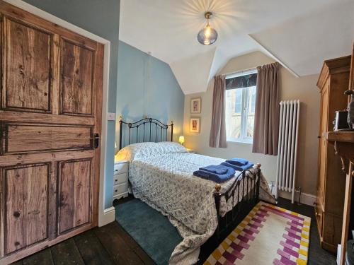 a bedroom with a bed and a large wooden closet at Katie's Cottage in Church Stretton