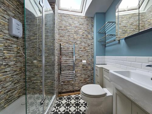 a bathroom with a shower and a toilet and a sink at Katie's Cottage in Church Stretton