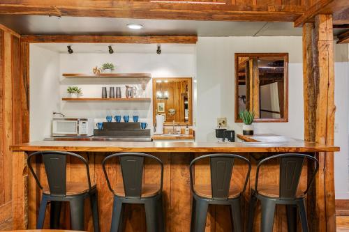 a kitchen with a bar with four chairs at Wildrest Hotel in Waynesville