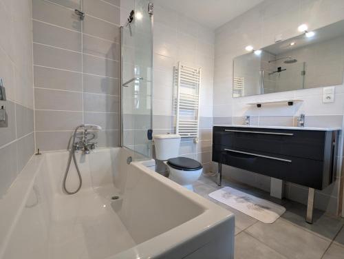 a bathroom with a tub and a toilet and a sink at La Chesnaie in Bonnes