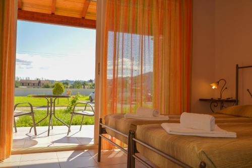 a bedroom with two beds and a balcony with a view at Megali Luxuries Apartments in Sidari