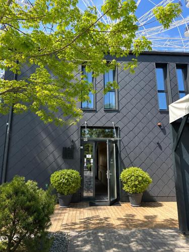 a building with an open door and some plants at Melt in Palanga Self check-in in Palanga