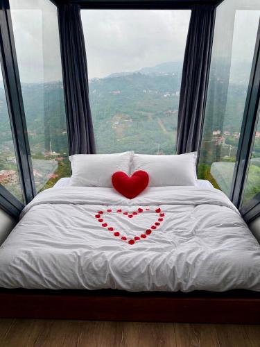 two hearts on a bed in front of a window at Lazord Glass Bungalow Trabzon in Geçit
