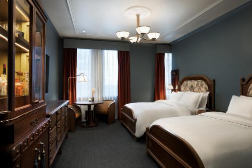 a hotel room with two beds and a window at The Driskill in Austin