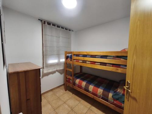 a small bedroom with a bunk bed and a window at Apartament l'Adou in Bagá