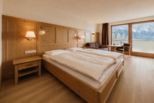 a bedroom with a large bed in a room at Hotel Plunger in Castelrotto