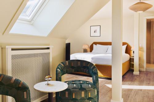 a bedroom with a bed and two chairs at Coco Hotel in Copenhagen