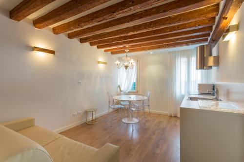 uma sala de estar com uma mesa e uma cozinha em Home Venice Apartments-Rialto 1 - 2 - 3 em Veneza