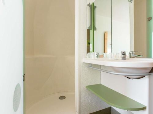 a bathroom with a sink and a mirror at ibis Budget Pau Est in Pau